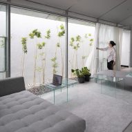 Sofa and tables in a lounge area that opens to a narrow outdoor space