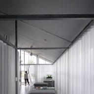 Mono-pitched hallway with a steel structure and white curtain wall