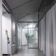 Mono-pitched hallway with a steel structure and white curtains