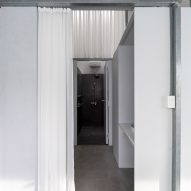 Hallway in a home with a steel structure and white curtains