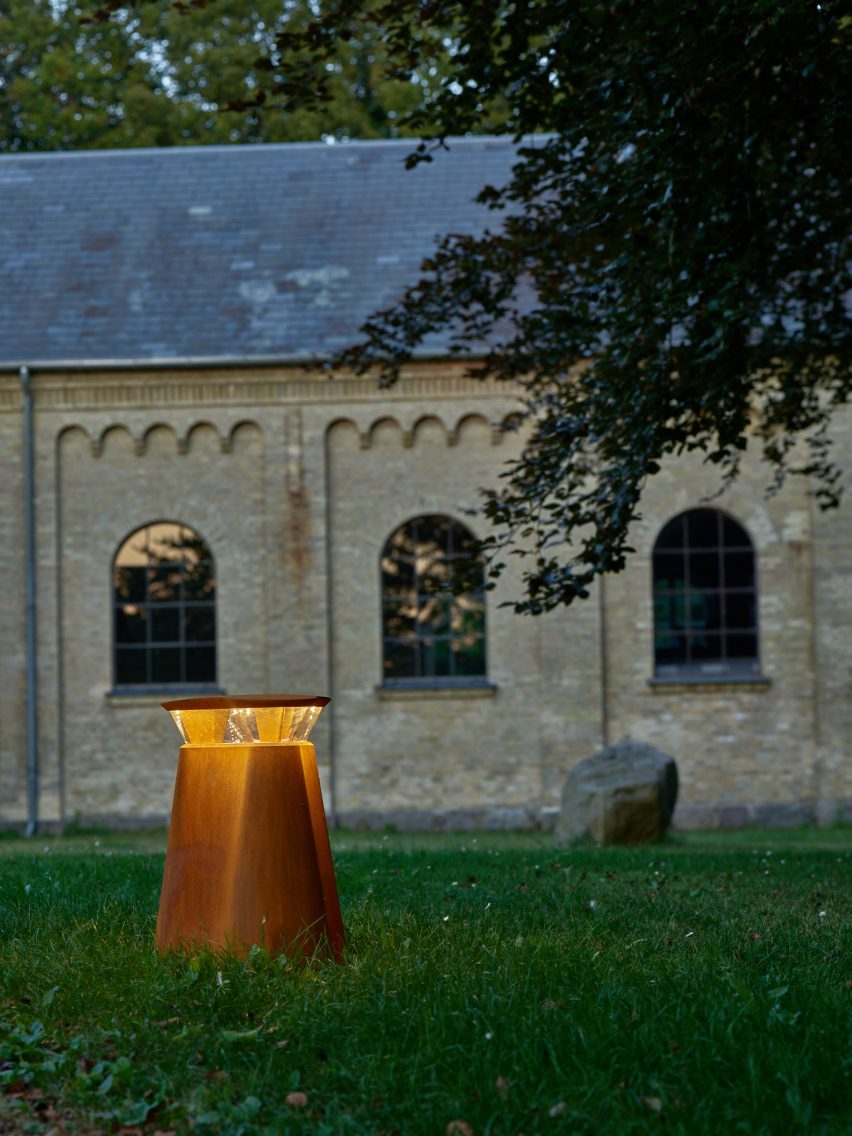 Bollard on a lawn with an old building in the background