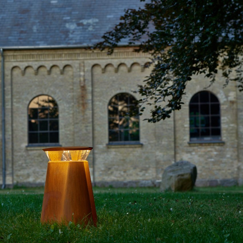 Bollard on a lawn with an old building in the background