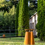 Bollard on a lawn with an old building behind it