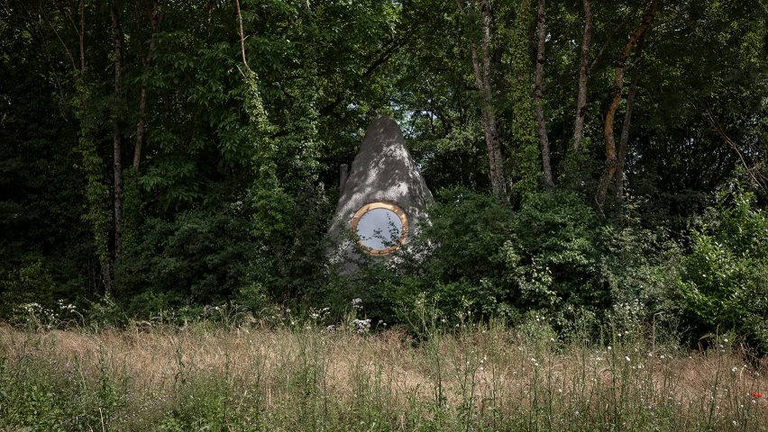 Cabaña con forma de roca en un bosque