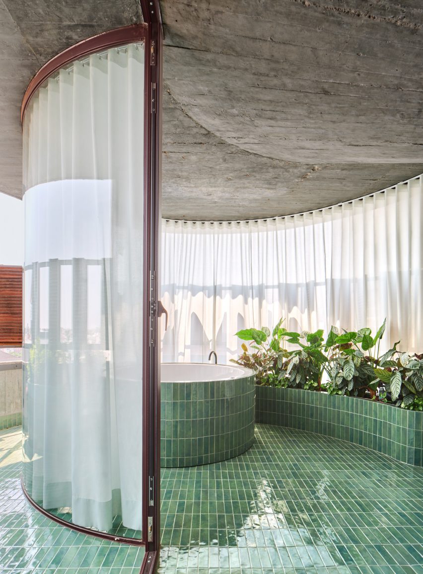 Outdoor green tile-clad bathtub on terrace in Torres Blancas building