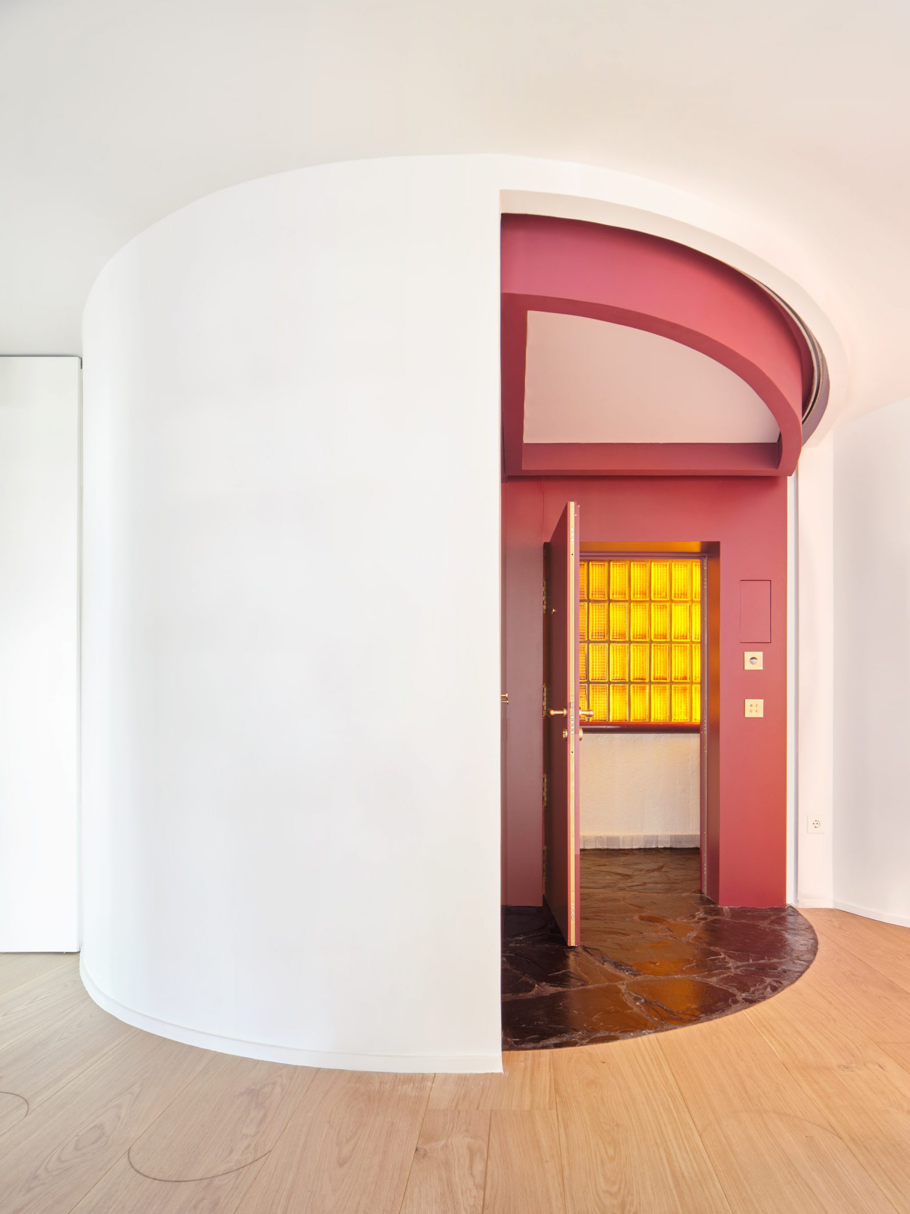 Semi-circular foyer with red-wine panelling within Torres Blancas apartment