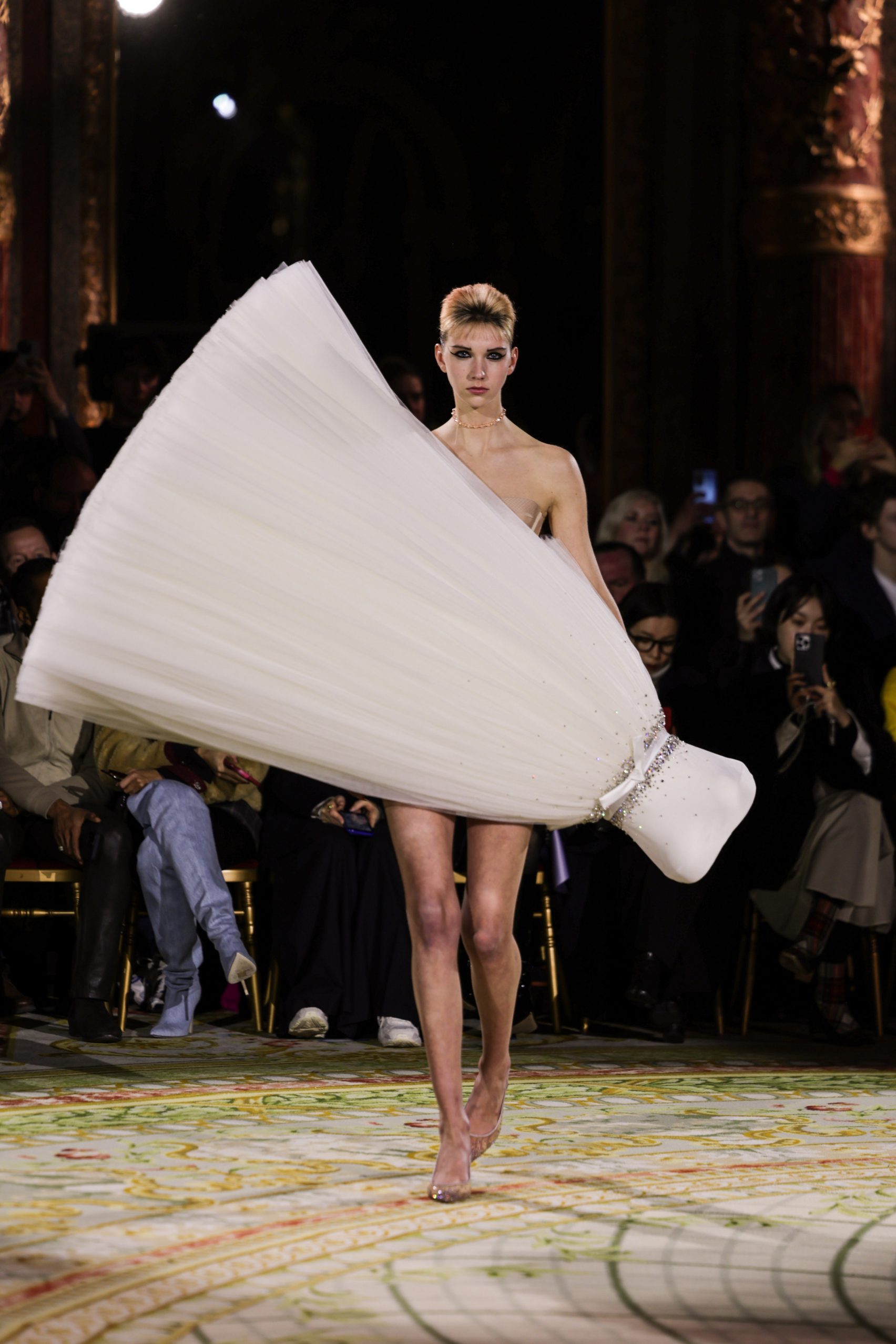 Slanted dress with tulle skirt positioned at a dramatic angle on a model