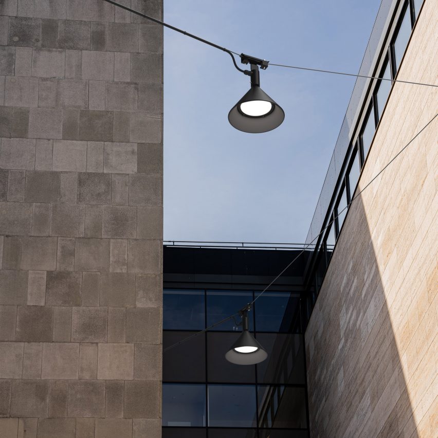 Black lamps suspended along wires between buildings