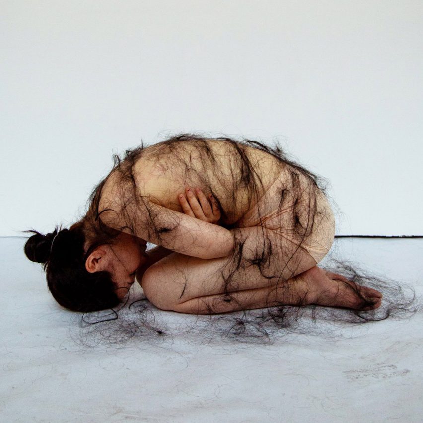 Image of a student draped in hair, which is part of an art project