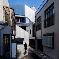 An alleyway in Japan leading to the steel-clad theatre building by Clouds AO