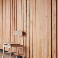 Neutral coloured chair against wood plank wall