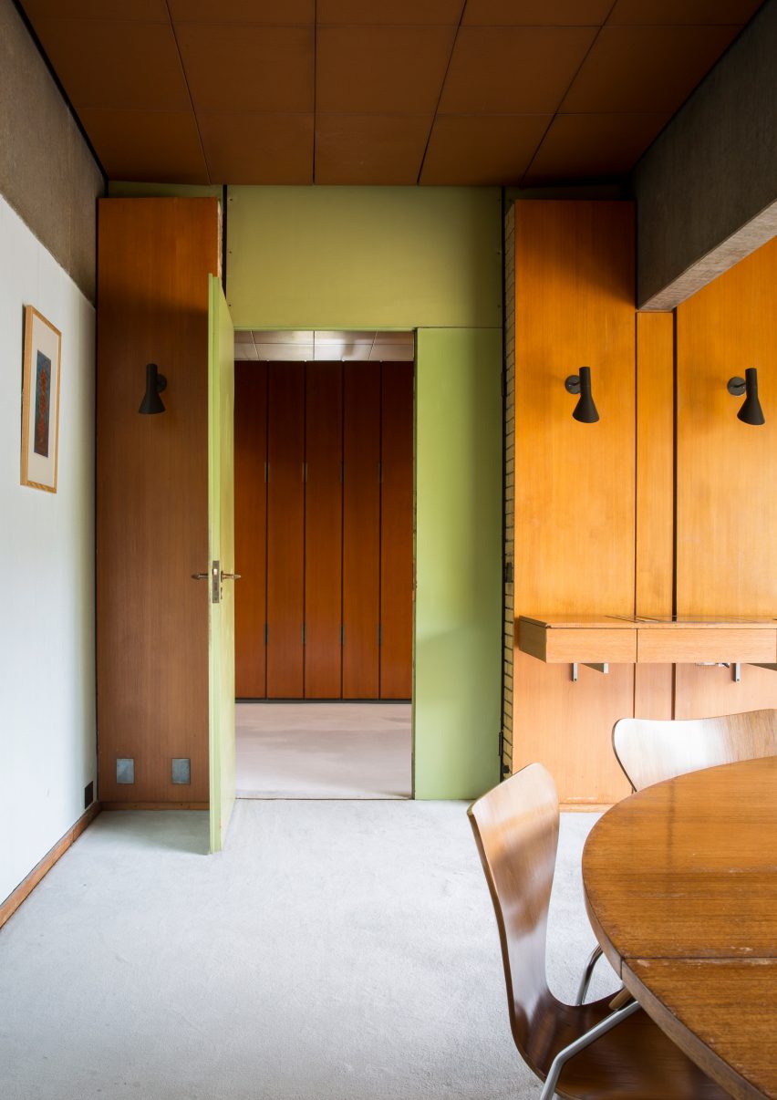 Photograph showing a room with wood paneling and a green wall