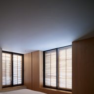 Bedroom with window shutters and and timber wall panelling