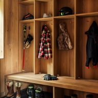 Timber-clad boot room with gridded wall storage for coats and hats