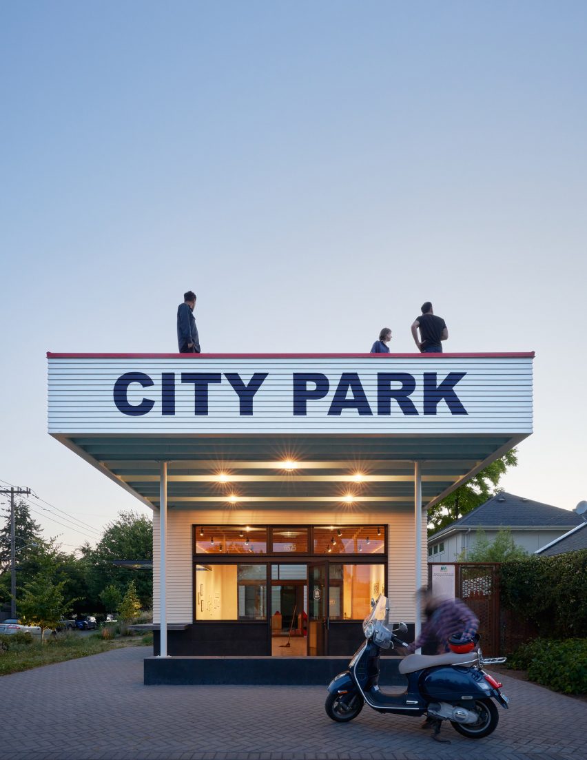 City Park sign with people standing on roof