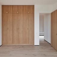 Room with white walls, timber flooring and built-in timber wardrobes