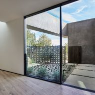 A room with large sliding glass doors leading to a planted roof terrace