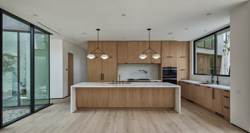 Kitchen with white walls, wood flooring, wooden kitchen cabinets and a wood kitchen island