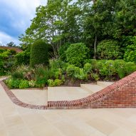 Planted garden with wide paved steps and a curved brick wall