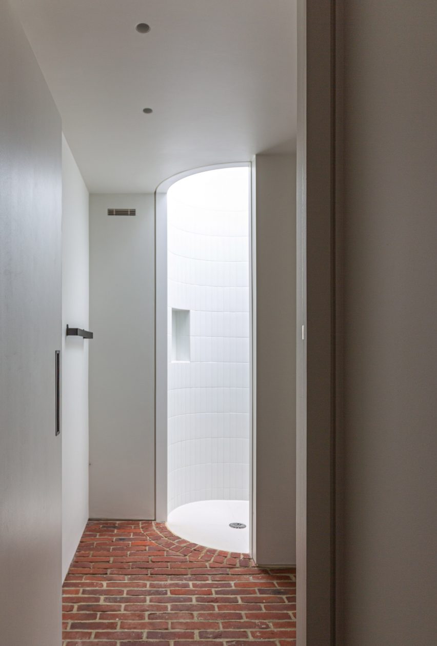 Bathroom with white walls, brick floor and circular shower