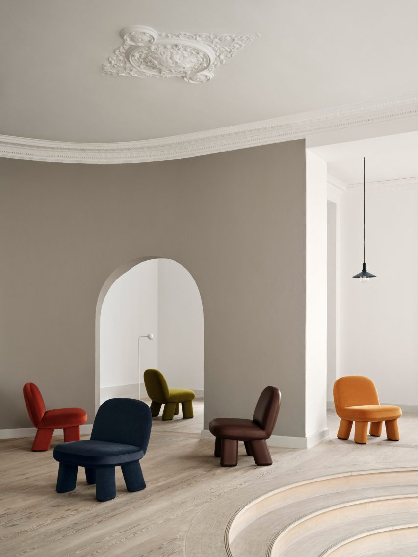 Five coloured chairs in high-ceilinged interior