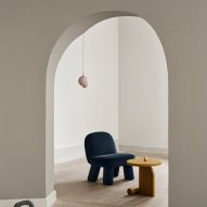 Blue rounded chair seen through interior archway