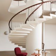 Red rounded chair below spiral staircase
