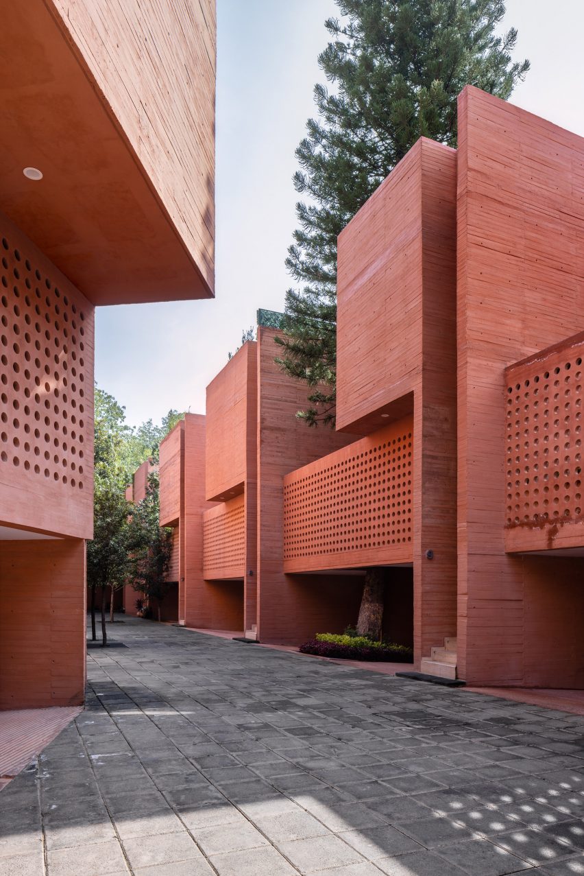 Perforations on facade of Mexican coloured concrete housing block 