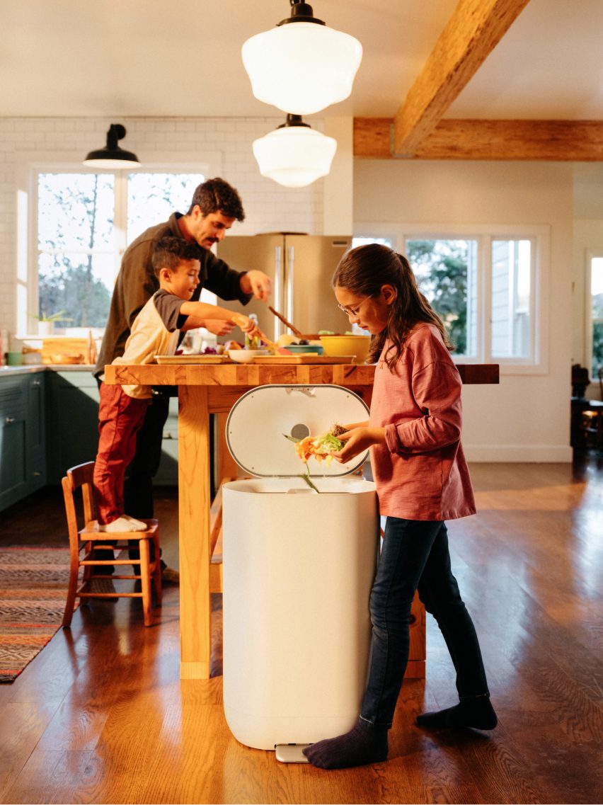 Photo of a girl pushing leftovers into the trash can in her family kitchen