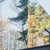 Mirror-clad structure reflecting the surrounding forest