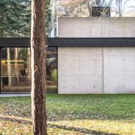 Two-storey home in a forest with concrete, glass and mirror facade