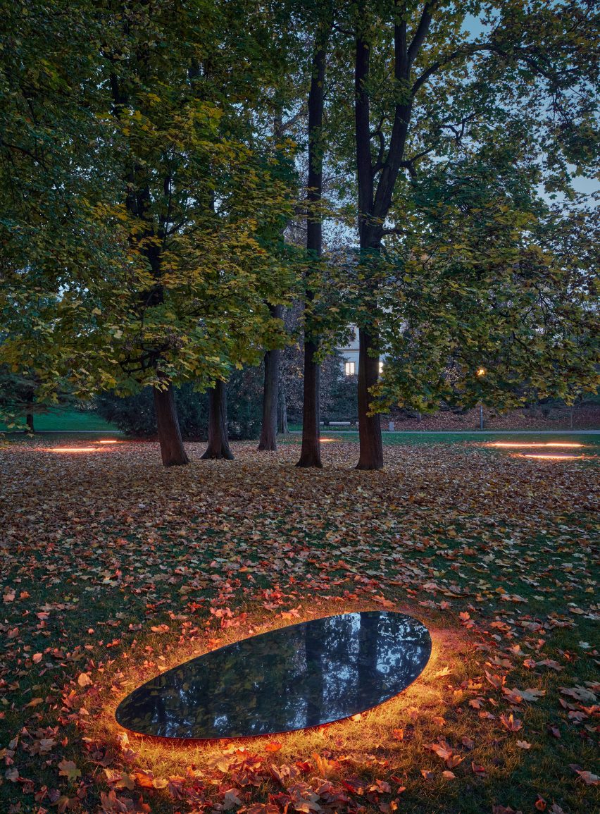 Aerial photograph of mirrors glowing on ground around trees at night