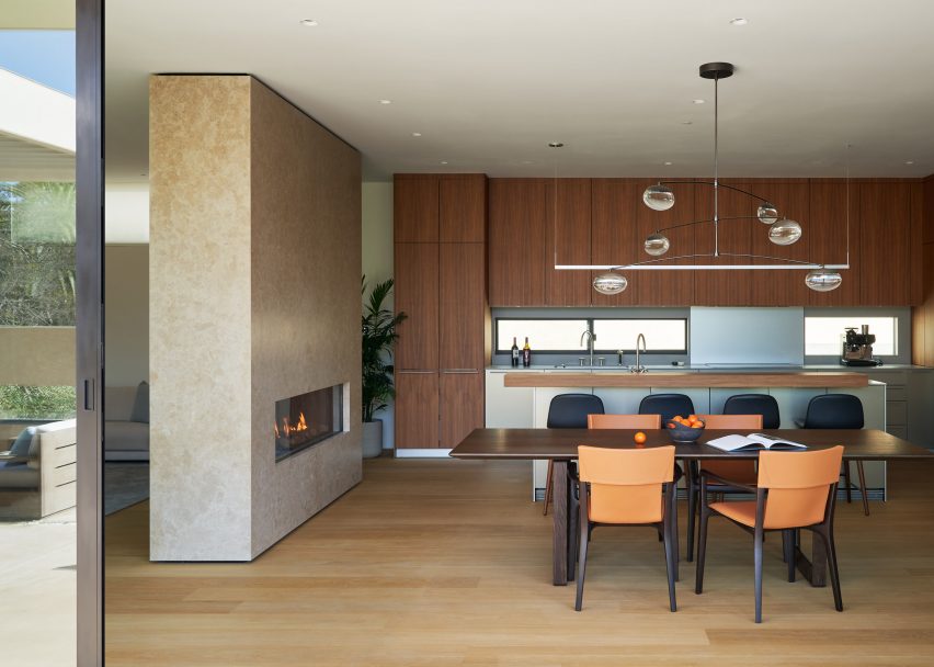 Limestone boxy fireplace within living space of Californian house 