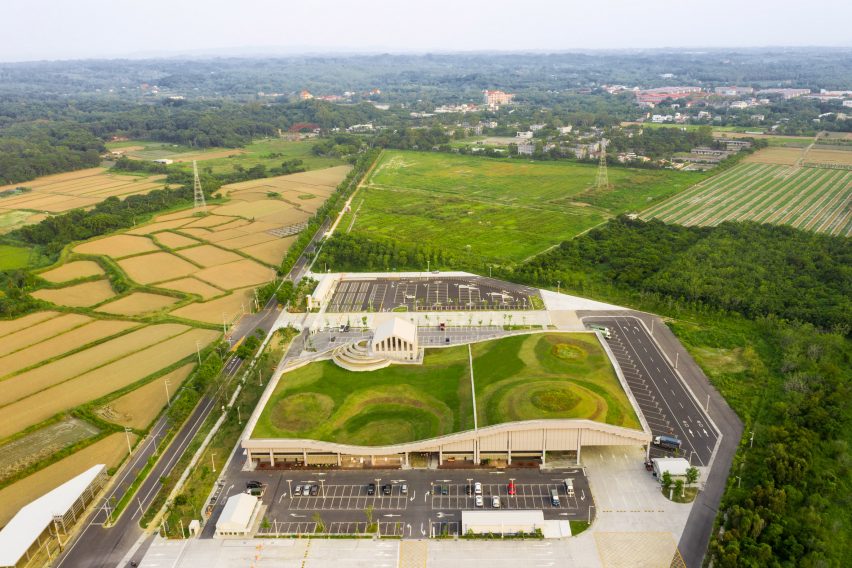 Market in Tainan with an undulating green roof surrounded by fields