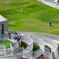 People walking on the undulating green roof and stepped terraces of the Tainan food market by MVRDV