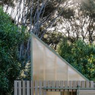 Top of a mono-pitched polycarbonate shed covered in timber battens in the New Zealand bush