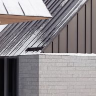 Close up of the granite walls and metal roofs of the Three Summits house by Nós