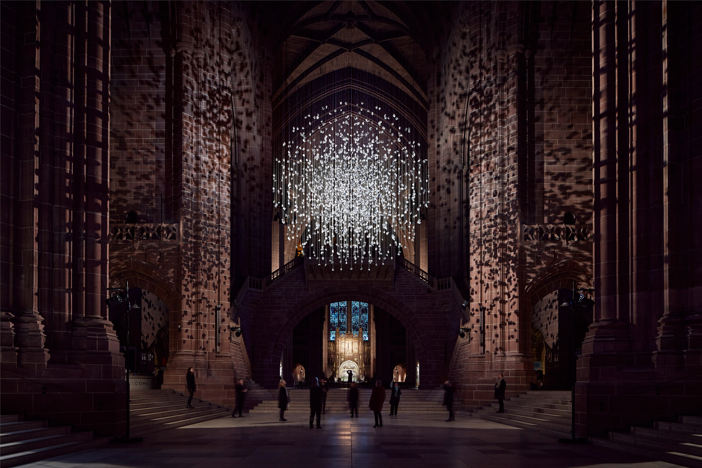 Spherical installation made up of suspended piece of coal illuminated inside a cathedral