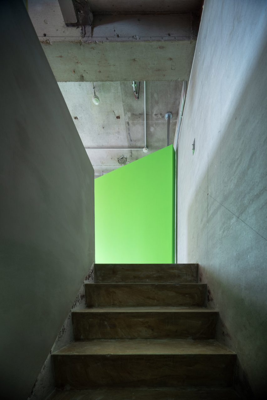 Fluorescent green rotating wall at the top of a concrete staircase