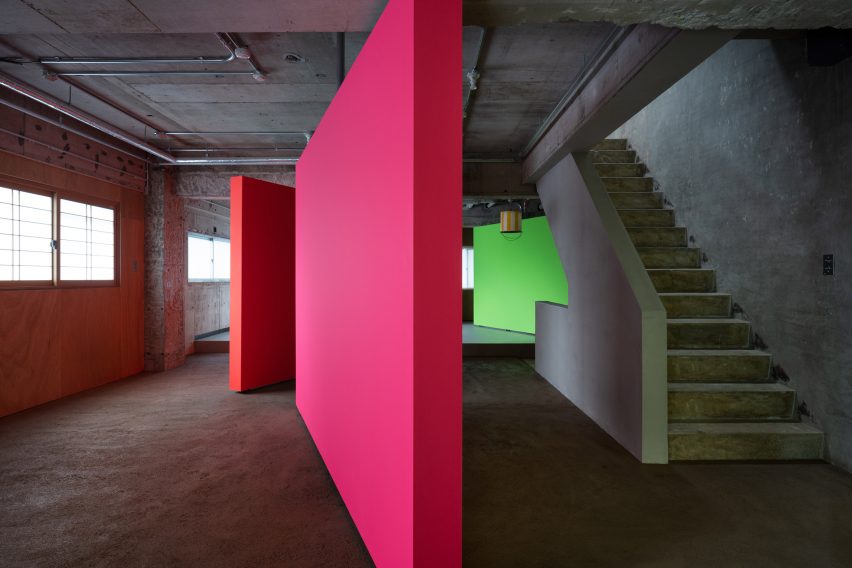 Pink, orange and green rotating partition walls in a concrete apartment by AB Rogers