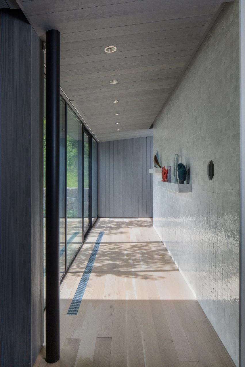 Corridors within blackened wood home by Desai Chai Architecture