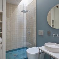 Bathroom with blue floor tiles, white sanitary ware and cream shower tiles
