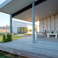 Timber porch with a sloping roof and sofa and lounge seating around a table