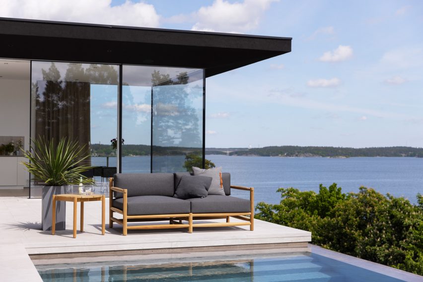 Grey upholstered sofa on a terrace by a pool with a sea view