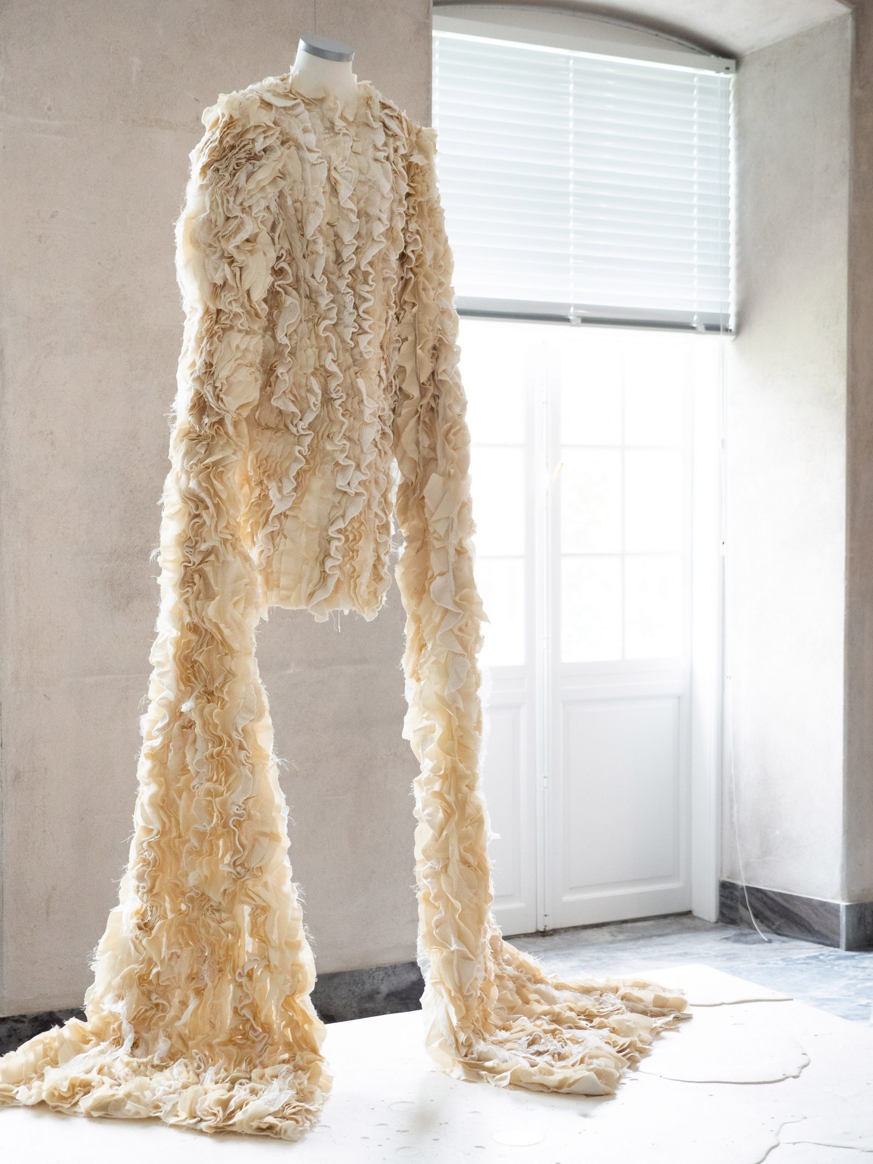 Ruffled dress made from dairy waste with bell sleeves on display at Designmuseum Denmark