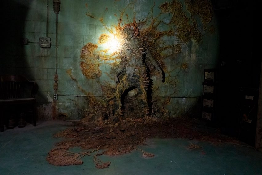 Body of infected covers wall in The Last of Us set design
