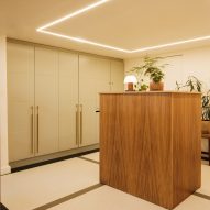 White room with recessed strip lighting, built-in wardrobes and wood table
