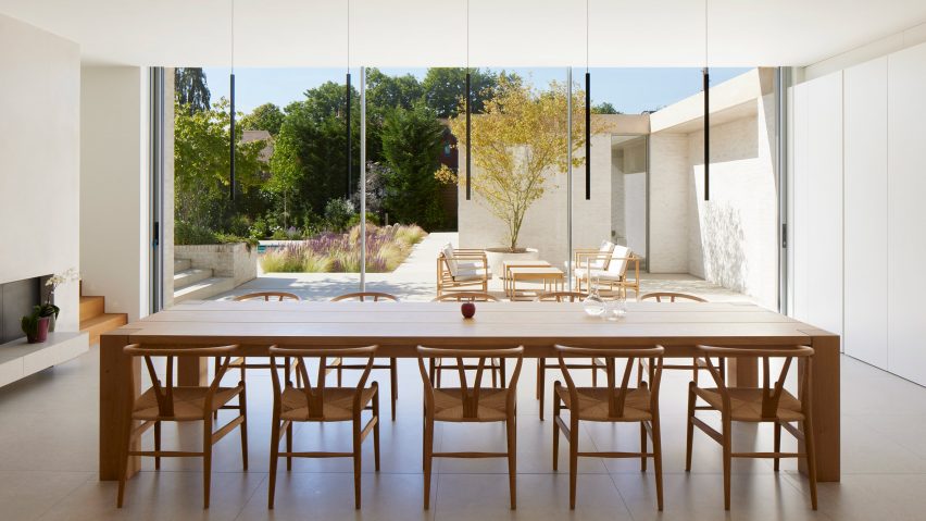 Dining table in front of sliding glass doors at The Pines house extension by Ström Architects