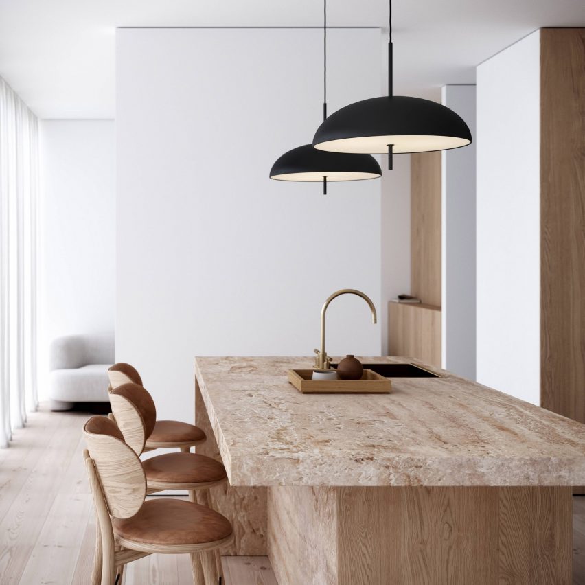 Two black pendant lamps hung over a wood kitchen island with a sink and wooden chairs