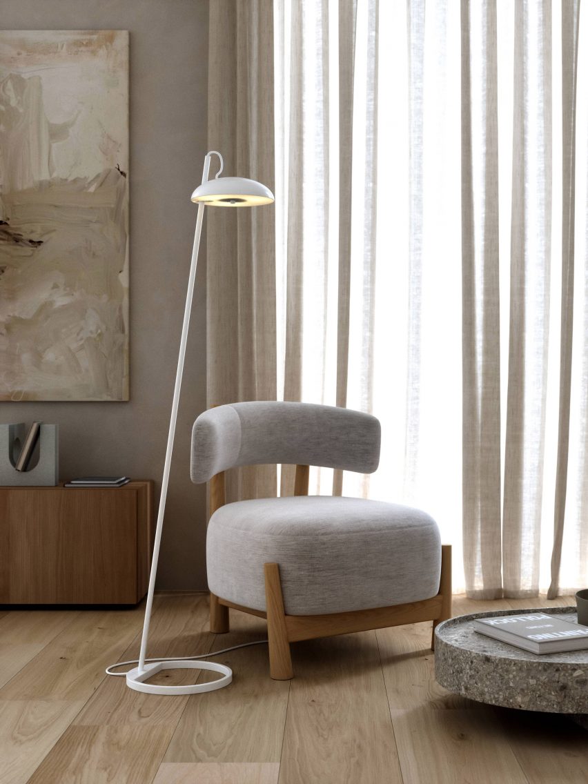 White floor lamp next to an upholstered lounge chair in a room with wood flooring